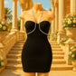 Abito nero elegante da donna, modello aderente senza spalline con scollo a cuore. Design sofisticato con spalline gioiello in strass, ideale per cerimonie, eventi serali o look da red carpet. Vestito da sera con stile glamour e dettagli luminosi, perfetto per valorizzare la silhouette femminile.