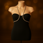 Abito nero aderente da donna, modello senza spalline con scollo a cuore e dettaglio gioiello tipo halter che valorizza il décolleté. Vestito da sera elegante e sensuale, perfetto per eventi formali, cerimonie o serate glamour. Design sofisticato che esalta la silhouette femminile con un tocco di lusso.